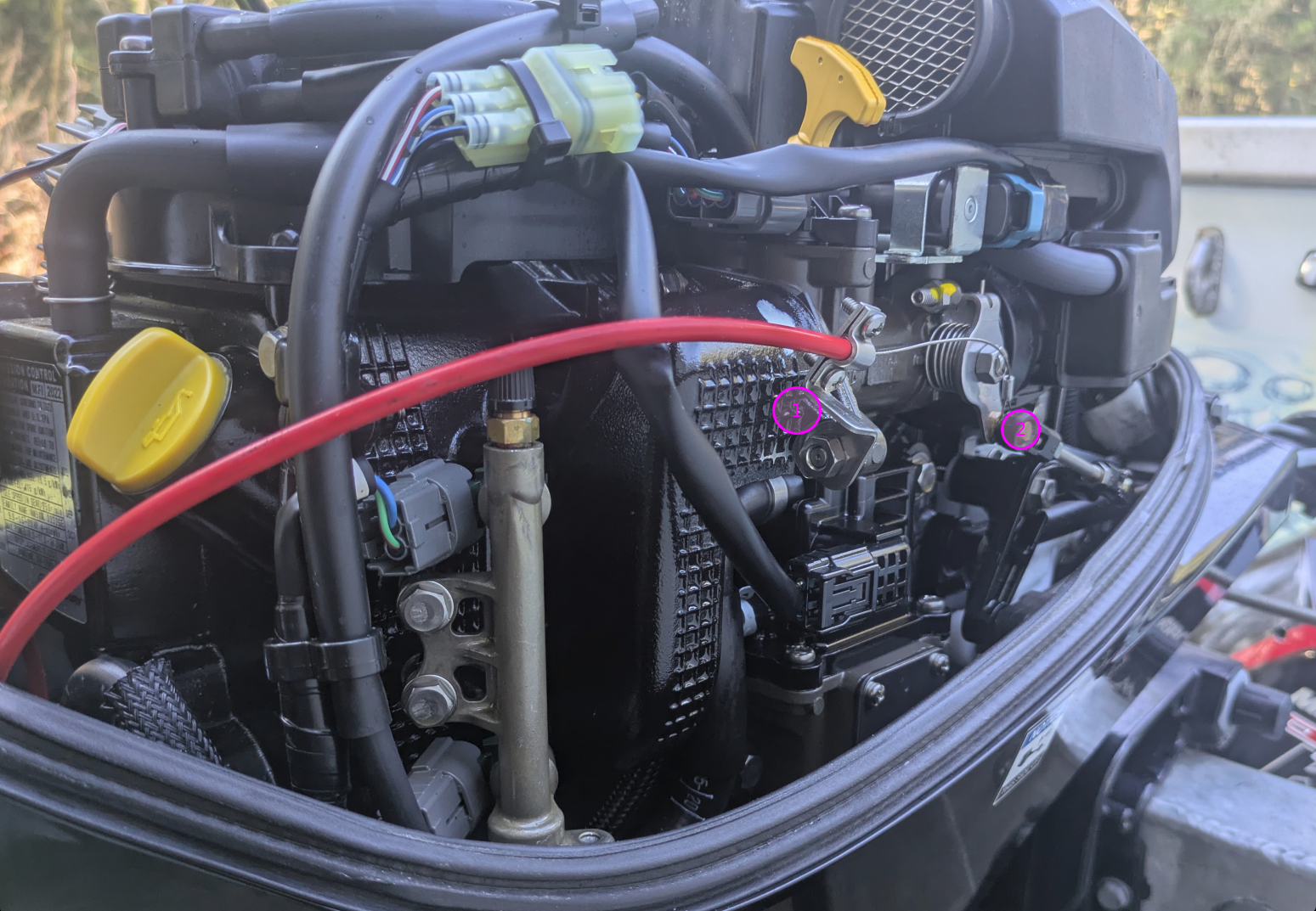 Bowden cable end at location 1 and braided line looped around the brass throttle-body knob at location 2